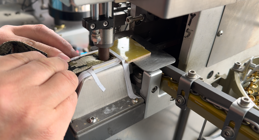 Hands guiding a fabric component at a machine workstation