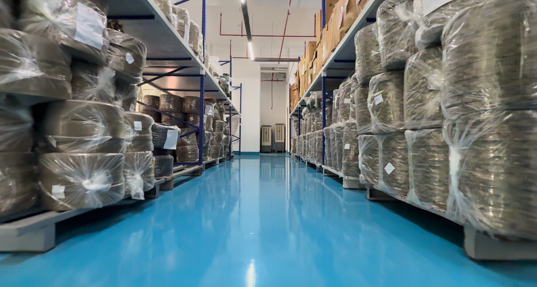 Bagged material rolls stored on racks along a production-area aisle