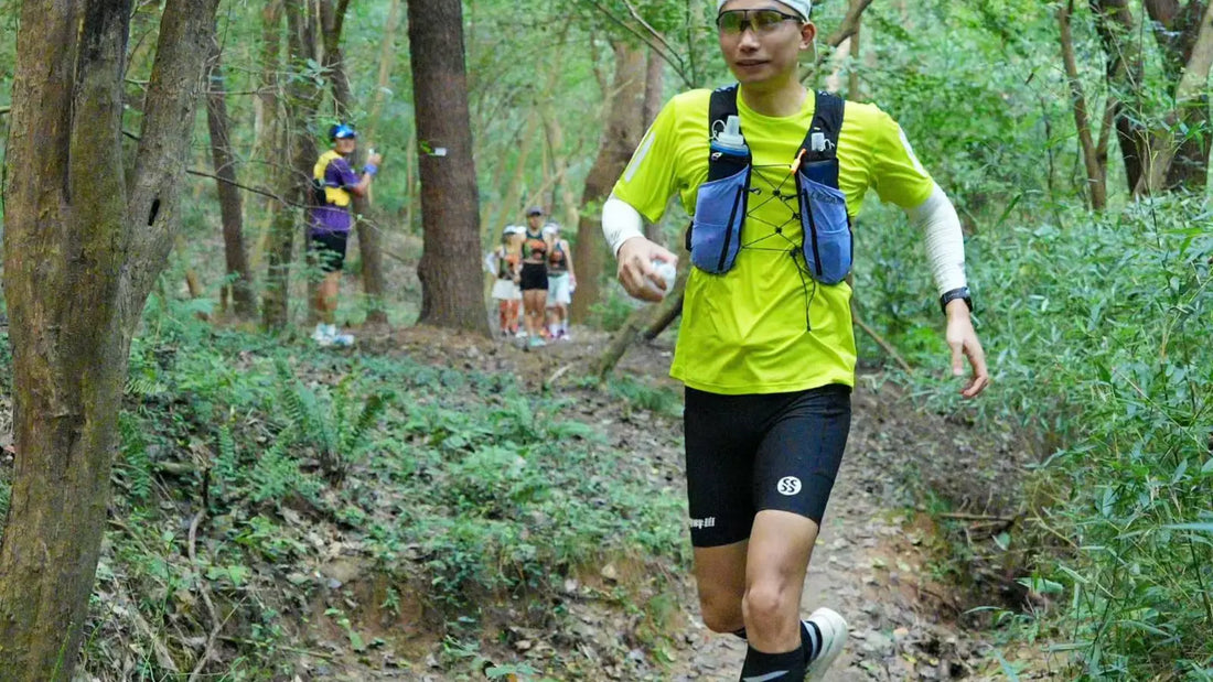 Trail runner wearing a loaded LECAMO hydration vest on a forest route