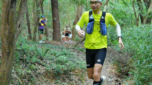 Trail runner wearing a loaded LECAMO hydration vest on a forest route